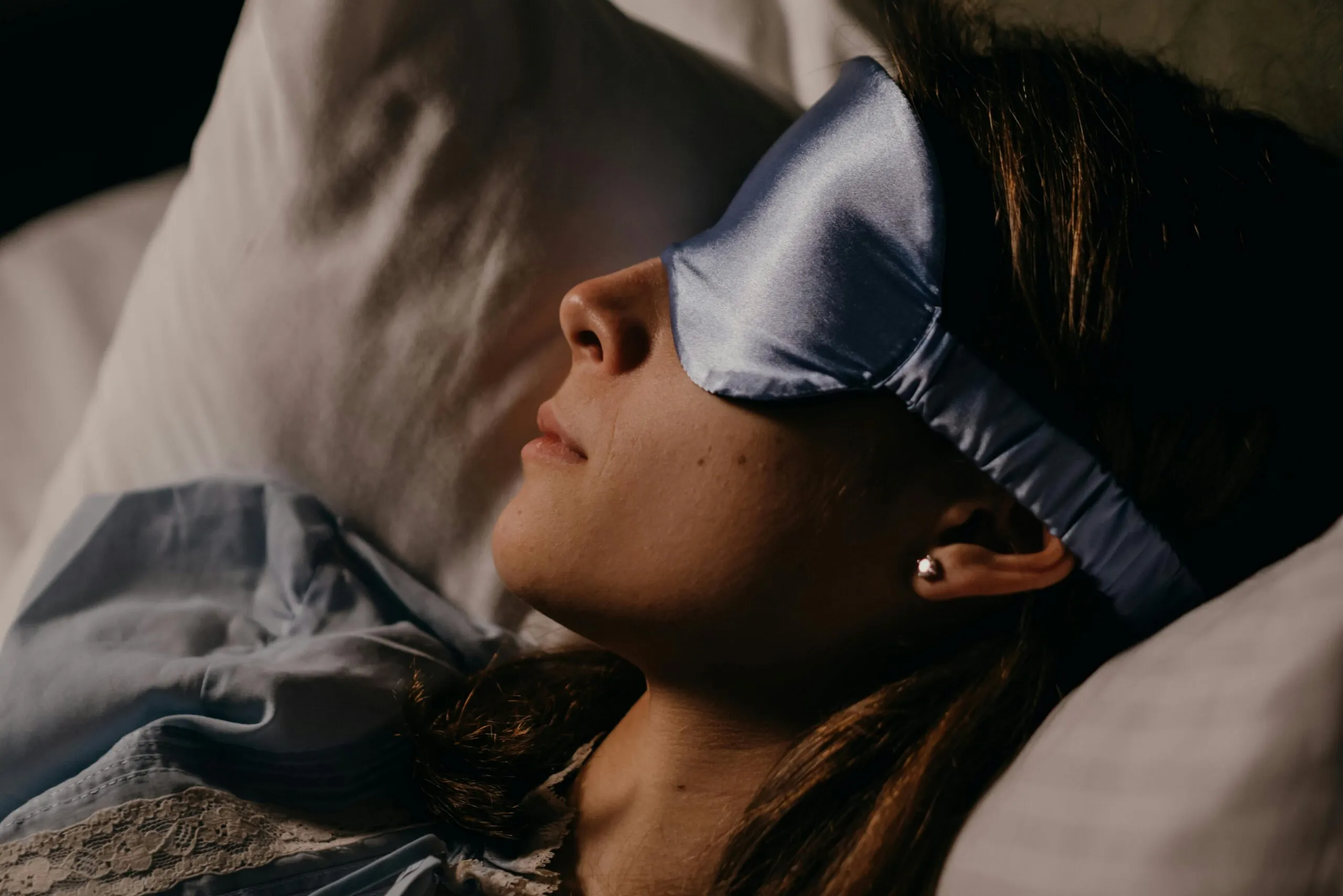 Woman sleeping peacefully with a silk sleep mask