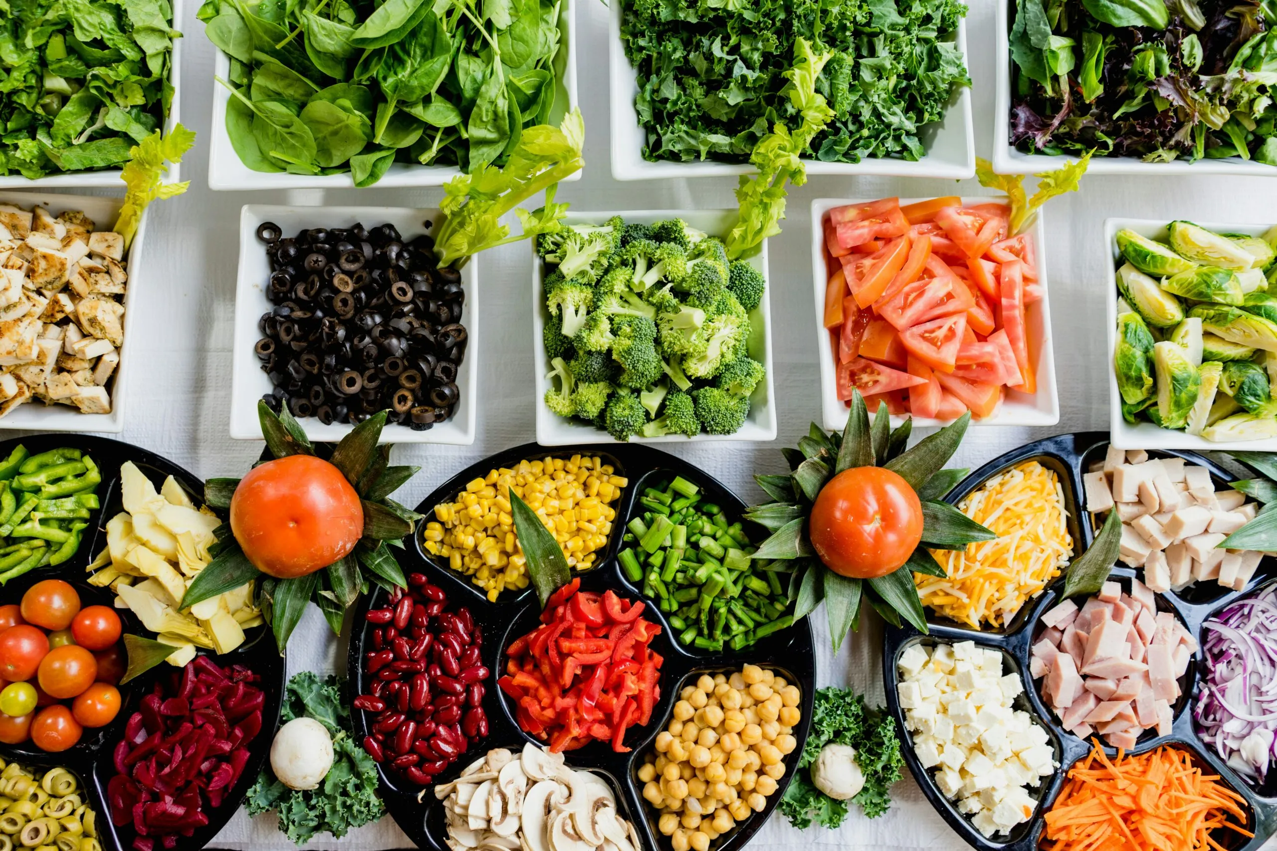 Bowls of colorful fresh vegetables, beans and greens
