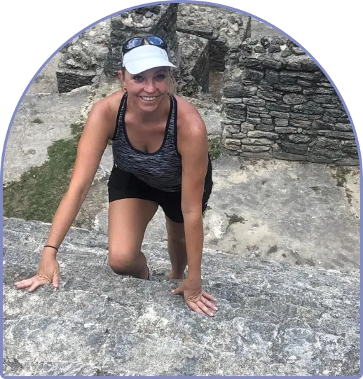 Robyn smiling while climbing ancient stone ruins