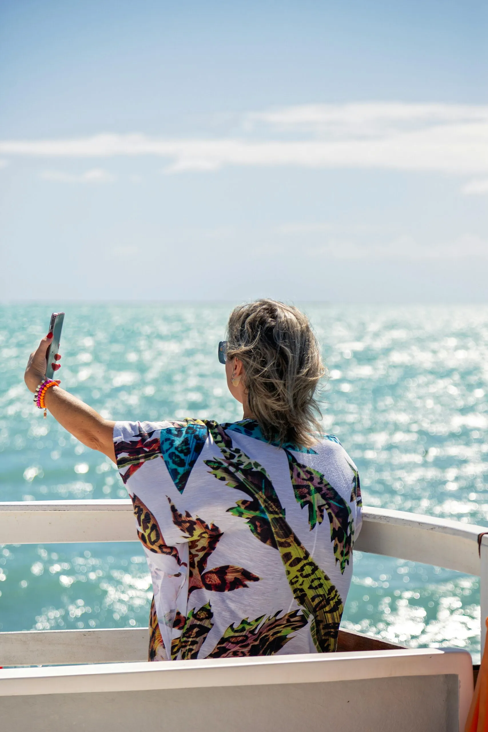 Woman taking a selfie on a cruise ship deck overlooking the ocean